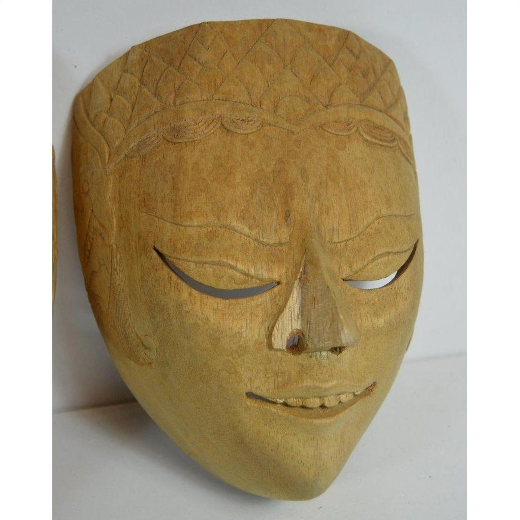Close-up of a Balinese dancing mask with closed eyes, gentle smile, and detailed forehead patterns, wood material.