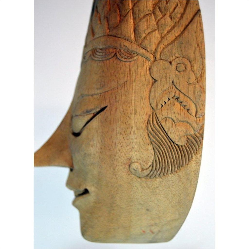 Brown wood Balinese masks with carved features and intricate patterns, side profile view on a plain background.