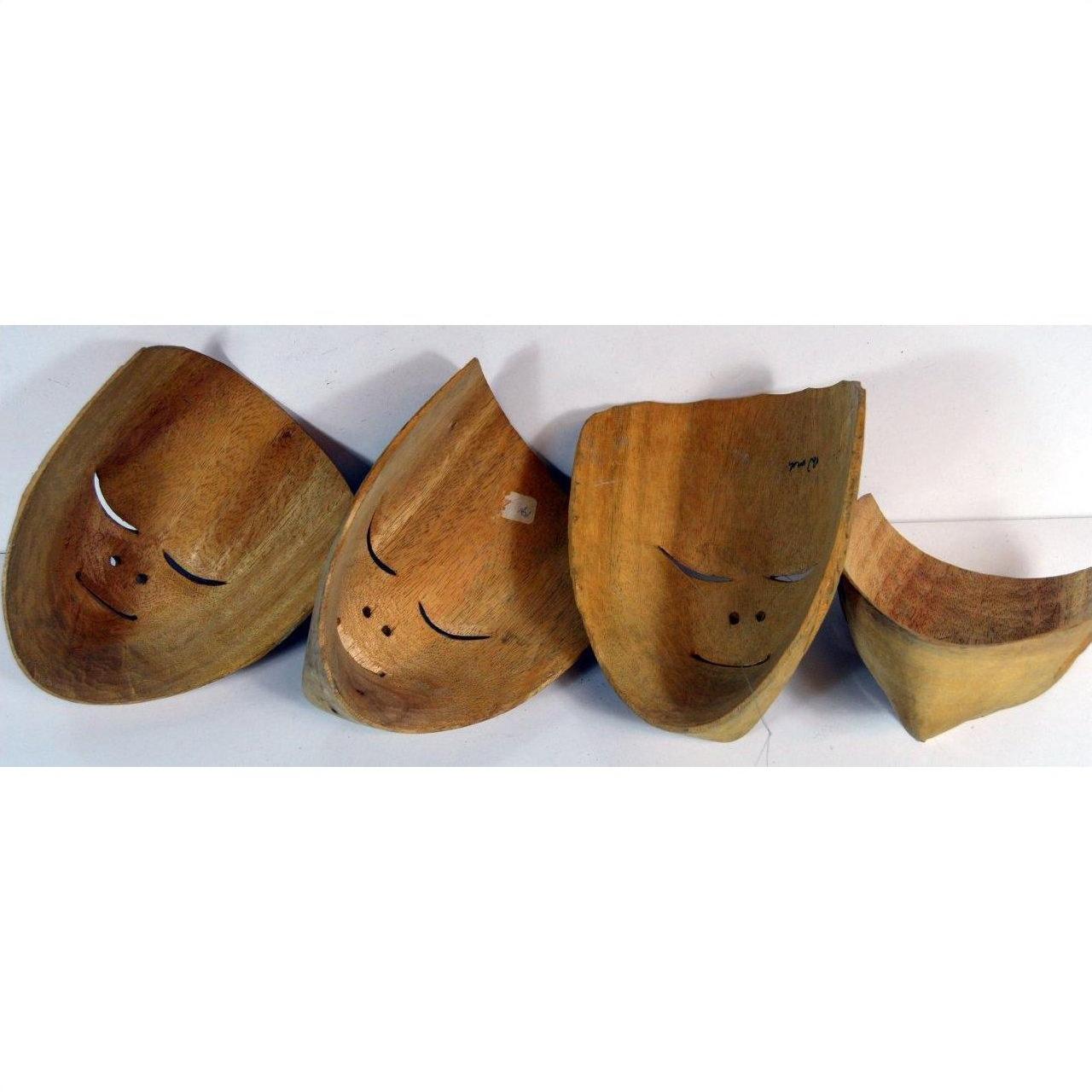 Brown and white carved Balinese masks, wood material, arranged in a row on a plain white background.