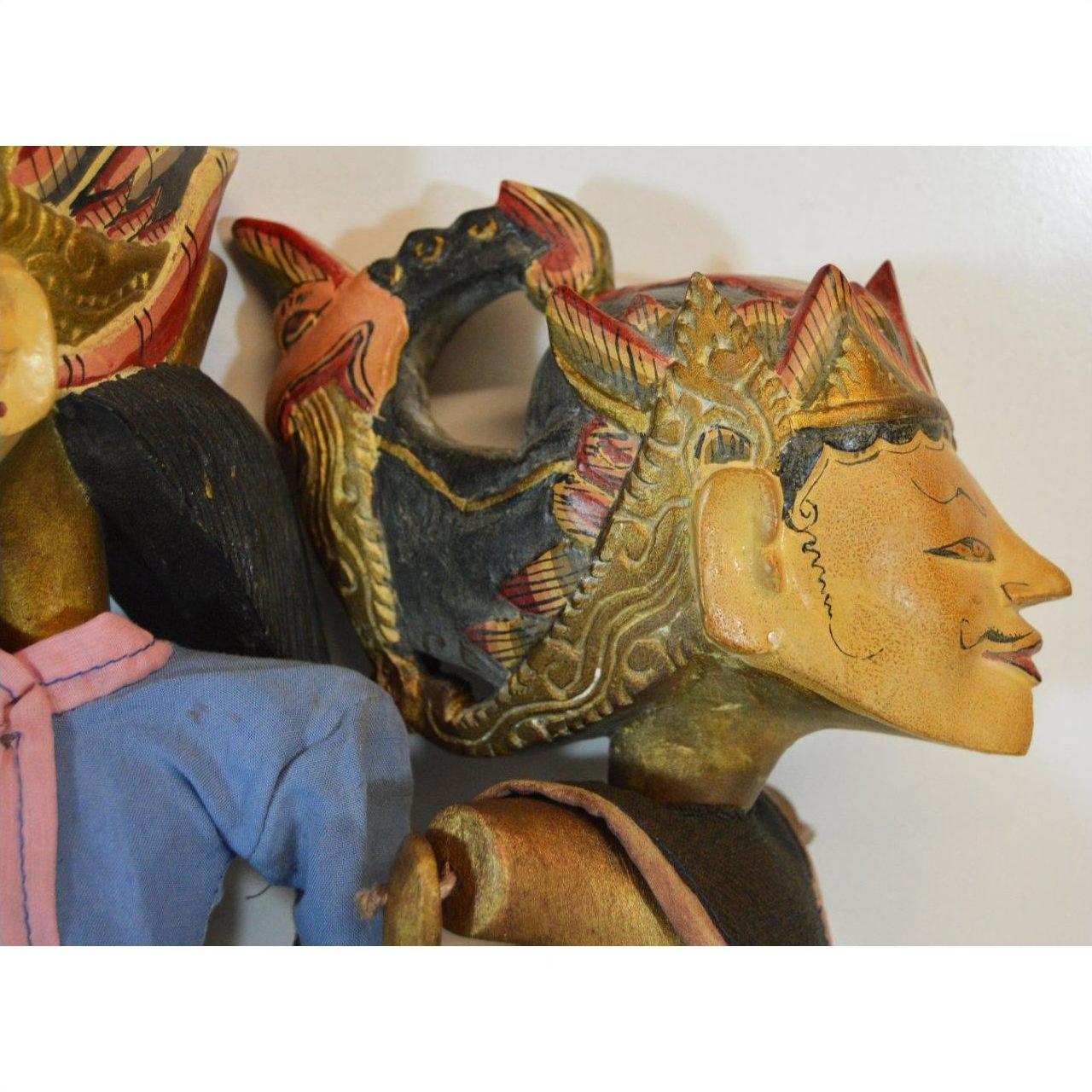 Close-up of a colorful wooden Balinese puppet with painted face and ornate hand-carved headdress.