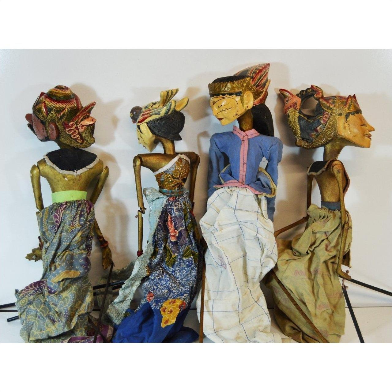 Colorful batik fabric Balinese puppets with backs facing camera, four grouped together.