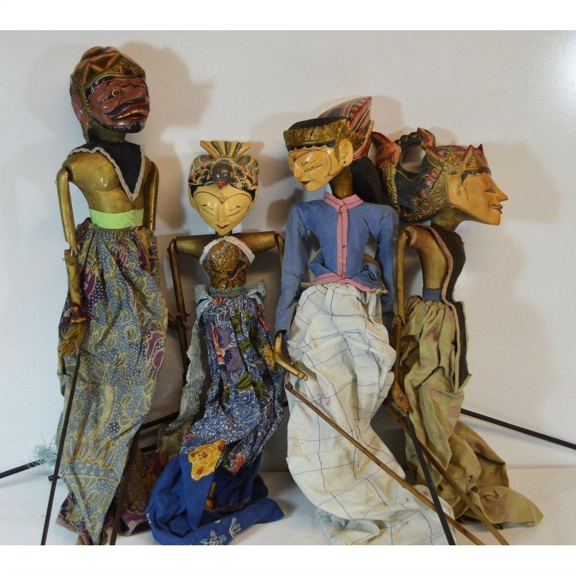 Colorful wooden Balinese puppets with hand-carved faces, close-up group view.
