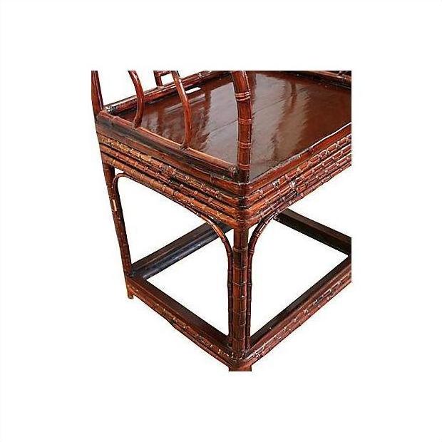 Close-up of dark bamboo horseshoe chair with woven detailing and glossy seat, 19th century style.
