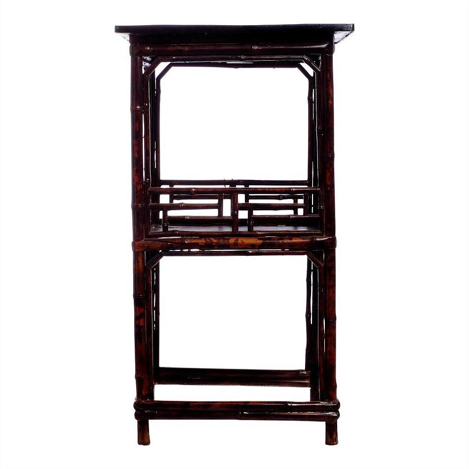 Dark lacquered bamboo lamp table with rectangular top and open shelving, studio product view.