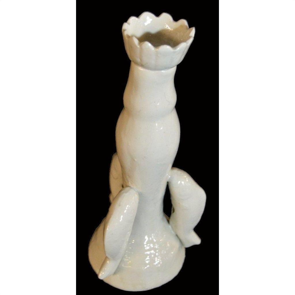 White porcelain candle holder with dolphin handles, Blanc de Chine, close-up against a black background.