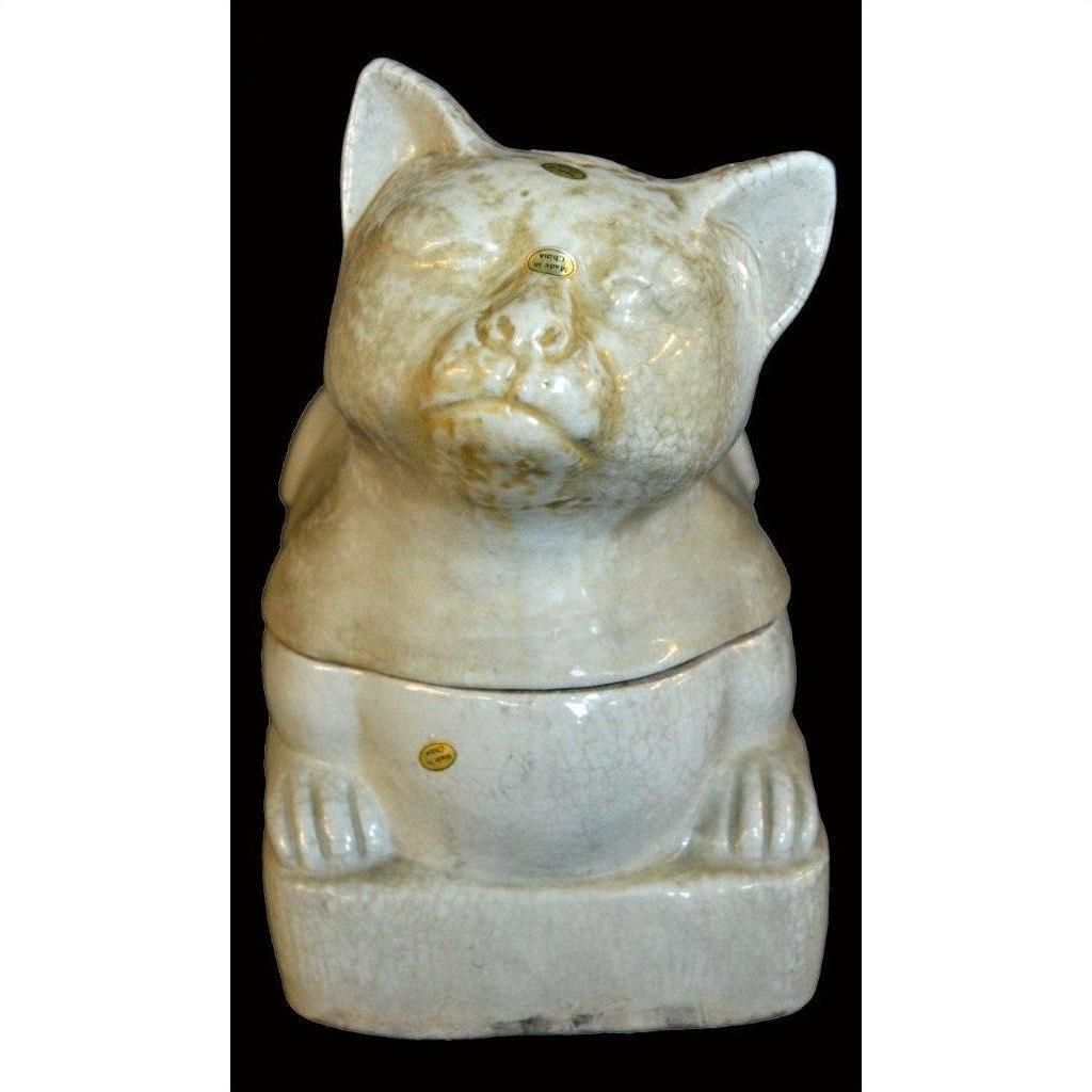 White porcelain Blanc de Chine cat on a rectangular base, close-up, set against a black background.