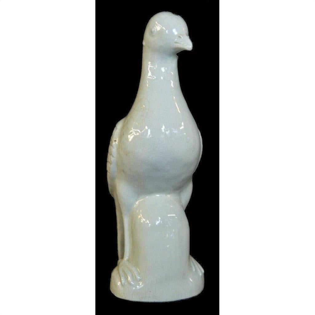 White porcelain dove figurine, Blanc de Chine, against black background.