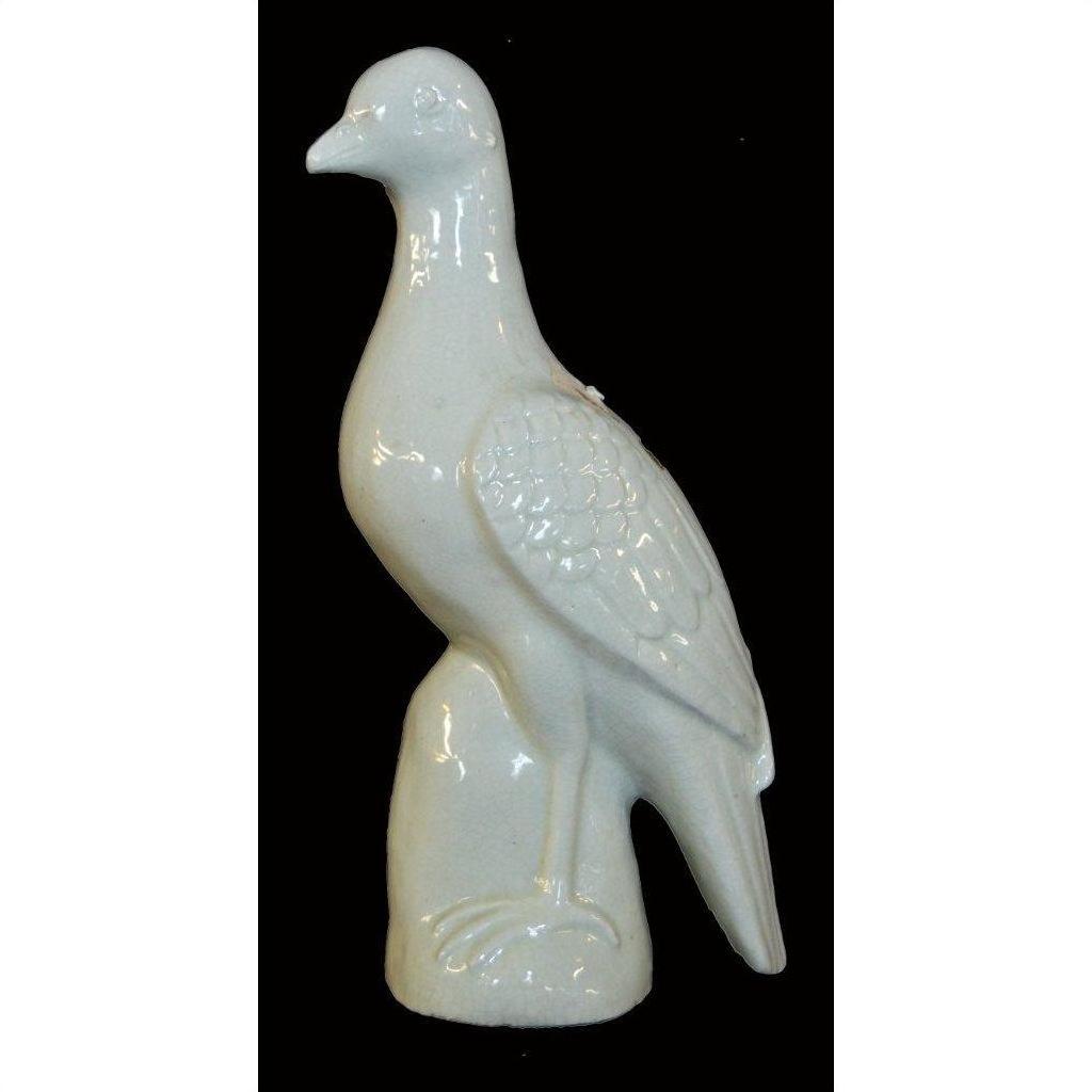White porcelain dove statue, Blanc de Chine, against a solid black background.