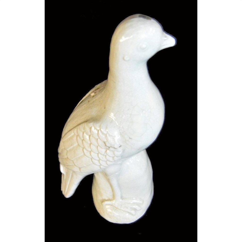 White porcelain dove with textured wings, Blanc de Chine style, against a black background.