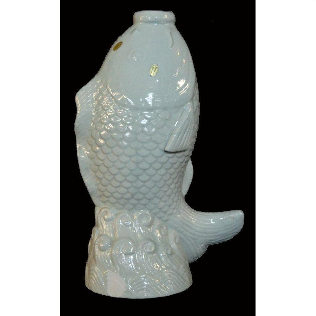 White porcelain fish figurine with detailed scales and waves on a black background.