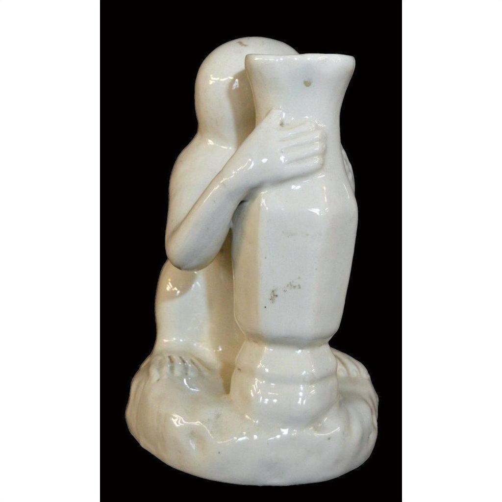 White Blanc de Chine porcelain monkey sculpture hugging a tall vase, detailed arms, hands, and feet, close-up.