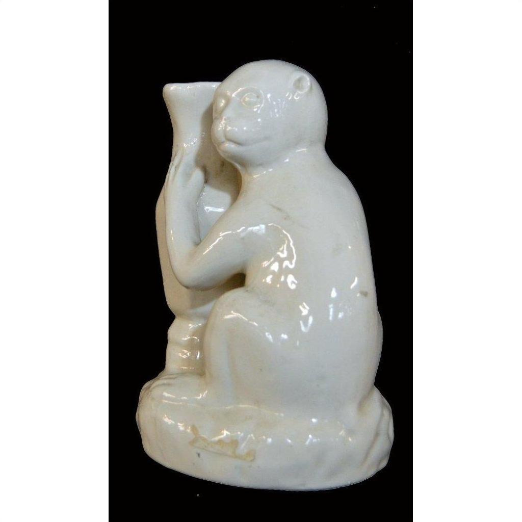 White porcelain monkey figurine holding vase on rounded base, modern style, close-up on black background.