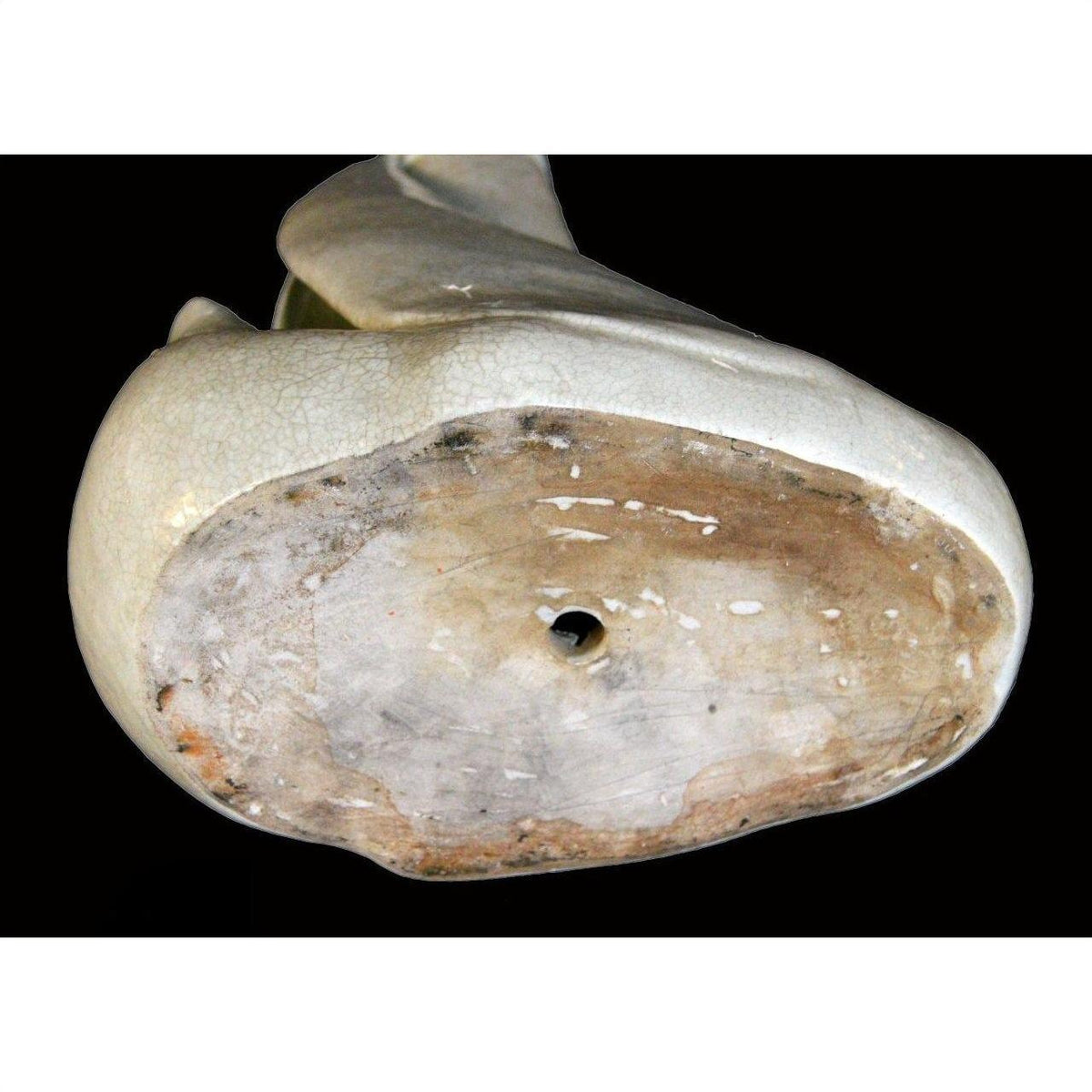 White porcelain vase with swan design, circular base, central hole, cracked glazed surface underneath.