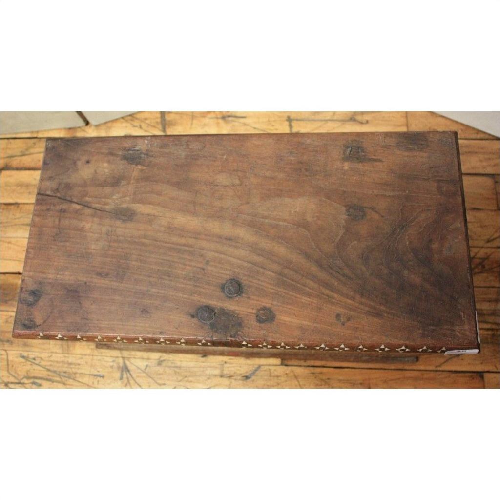 Dark wood Indonesian blanket chest with a weathered finish, placed on a wooden floor.