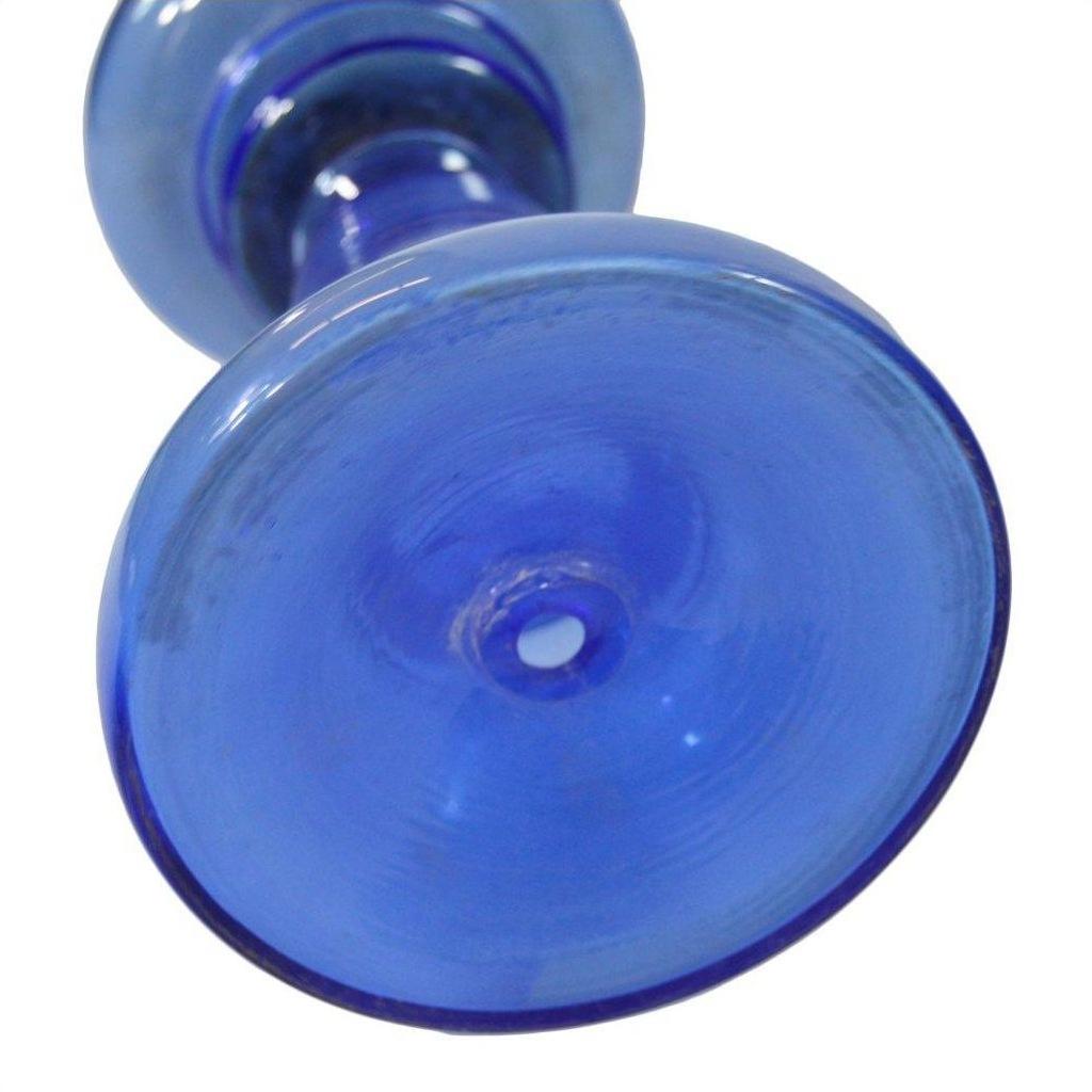 Close-up of antique blue glass oil lamp base, showing circular patterns and intact condition from an underside view.