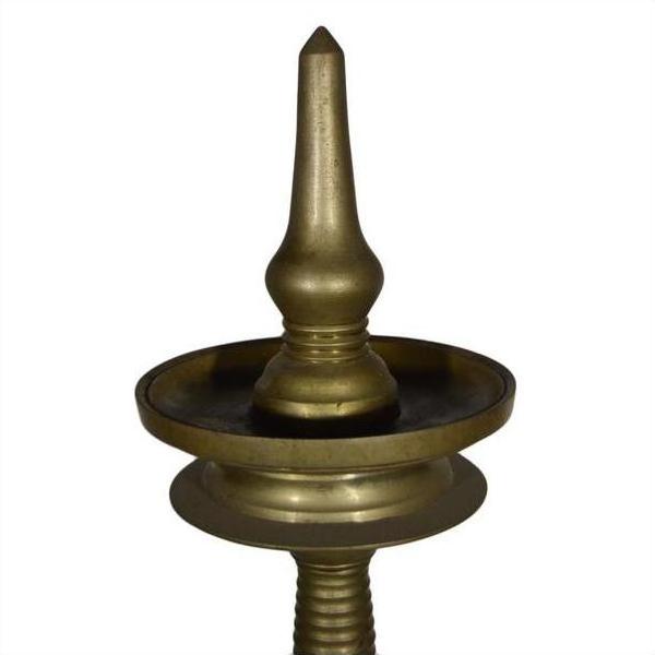 Close-up of an antique-style brass incense burner with a pointed top, set against a plain white background.