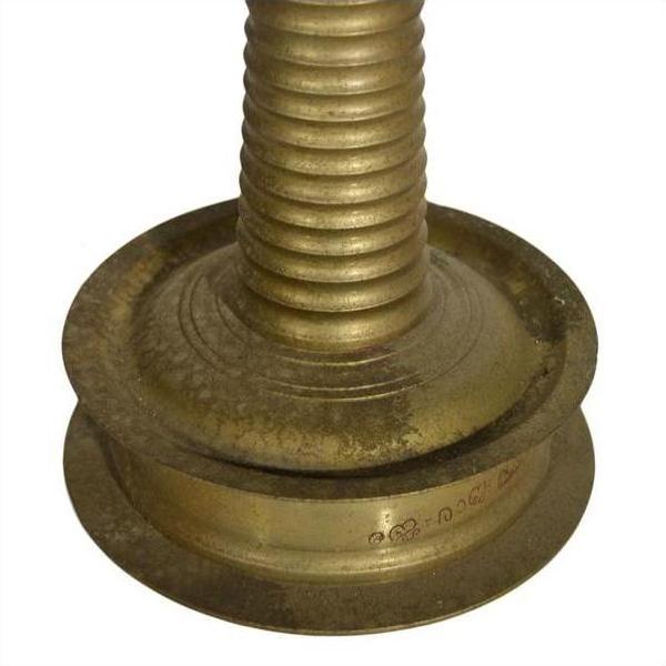 Close-up of brass incense burner base with engraved patterns and spiral design.