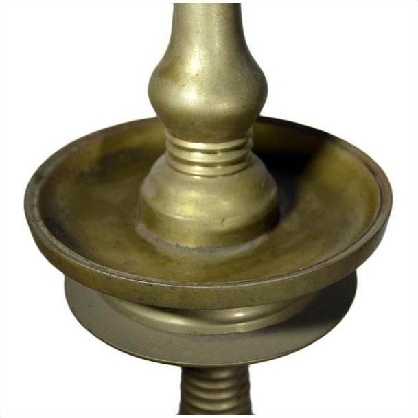 Close-up of brass incense burner with spiral design and round base on white background.