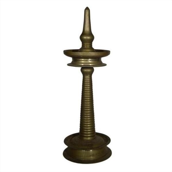 Close-up of a brass incense burner with spiral design and pointed top, inspired by antique Indian ceremonial lamps.
