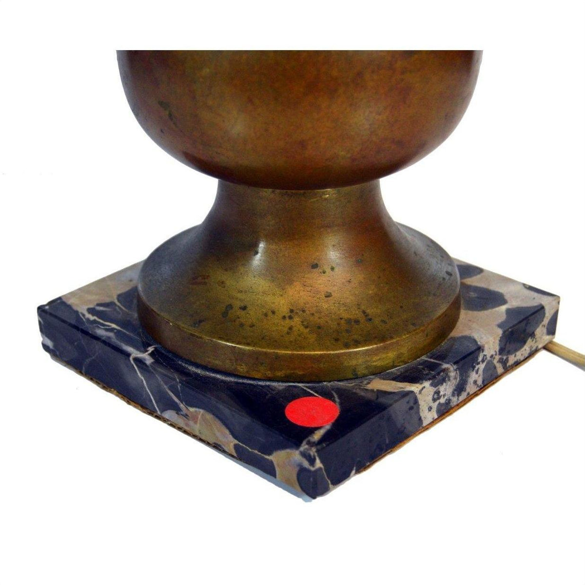 Close-up of brass lamp with shade on square marble base, small red dot sticker in corner.