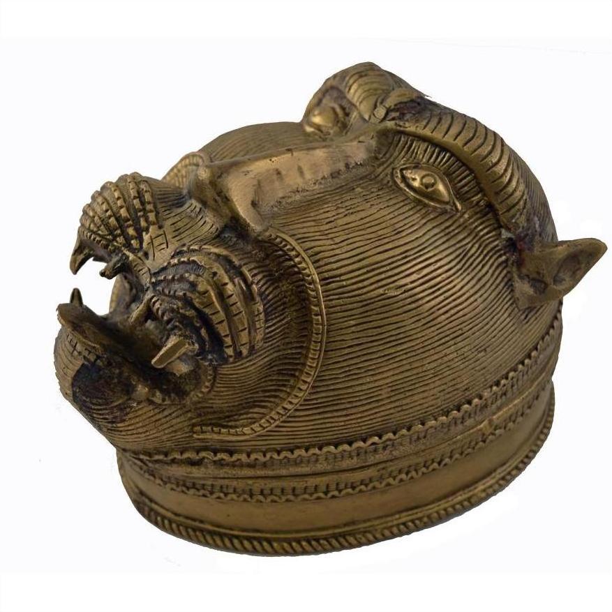 Close-up of a solid brass monkey head box with large teeth, a stylized mane, and engraved eyes.