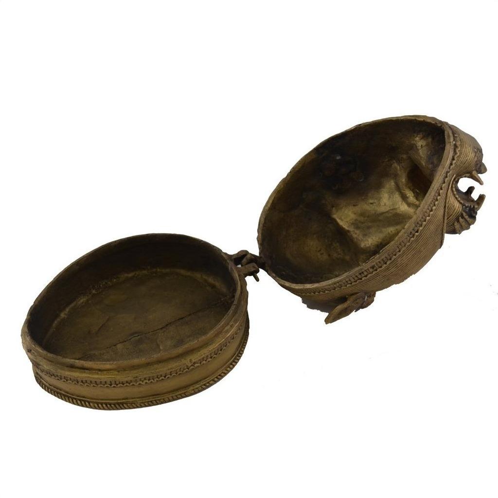 Close-up of a round brass box with a hinged lid and antique detailing, Brass Monkey Head Box.