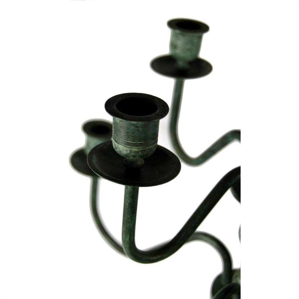 Close-up of bronze candelabra centerpiece with three empty candle cups against a white background.