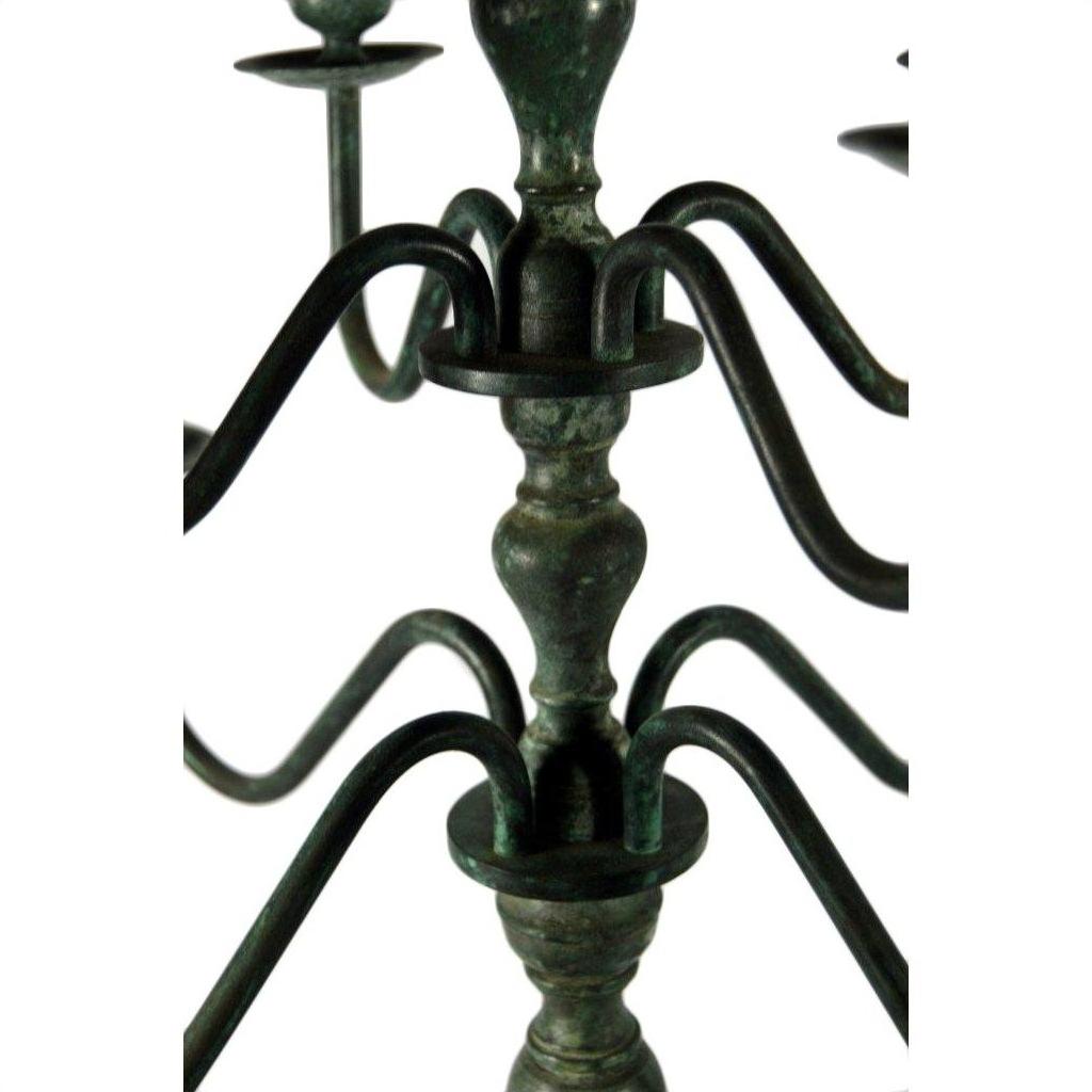 Close-up of bronze candelabra with curved arms and greenish weathered patina on centerpiece.