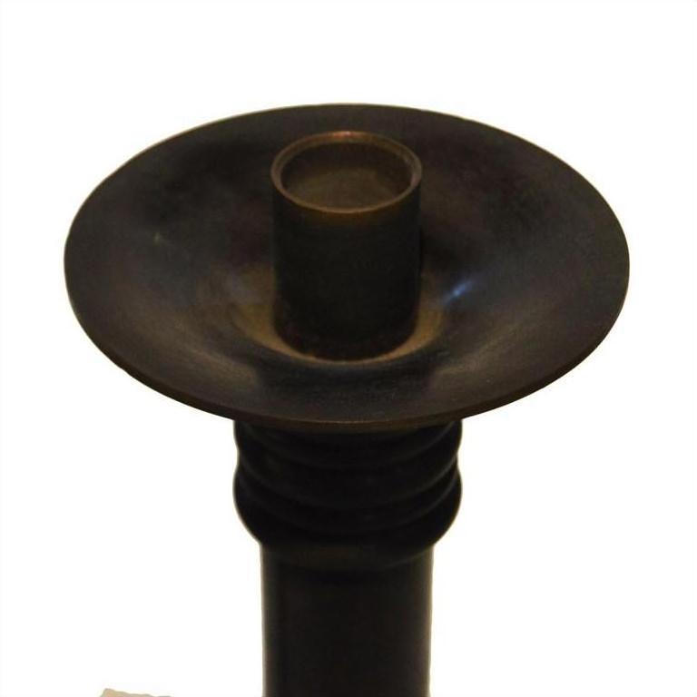 Close-up of dark bronze Japanese candle holder with wide shallow dish and cylindrical center.