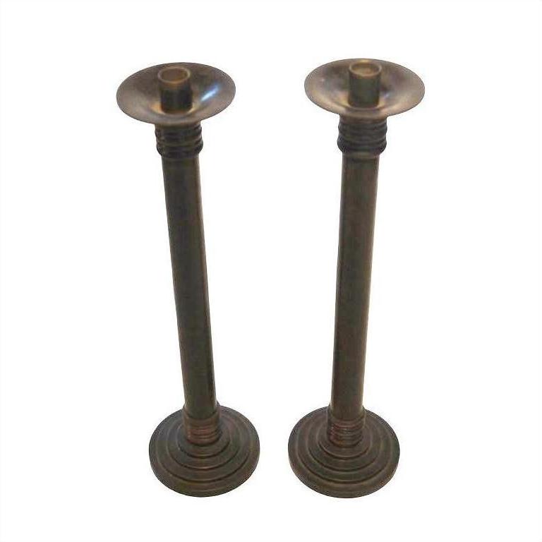 Bronze candle holders with round bases and classic Japanese design, close-up view, standing side by side.