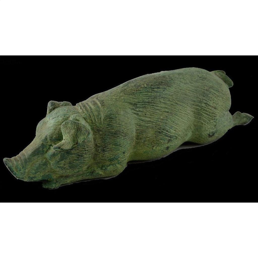 Bronze pig sculpture lying on its side against a solid black background, tabletop decor close-up.