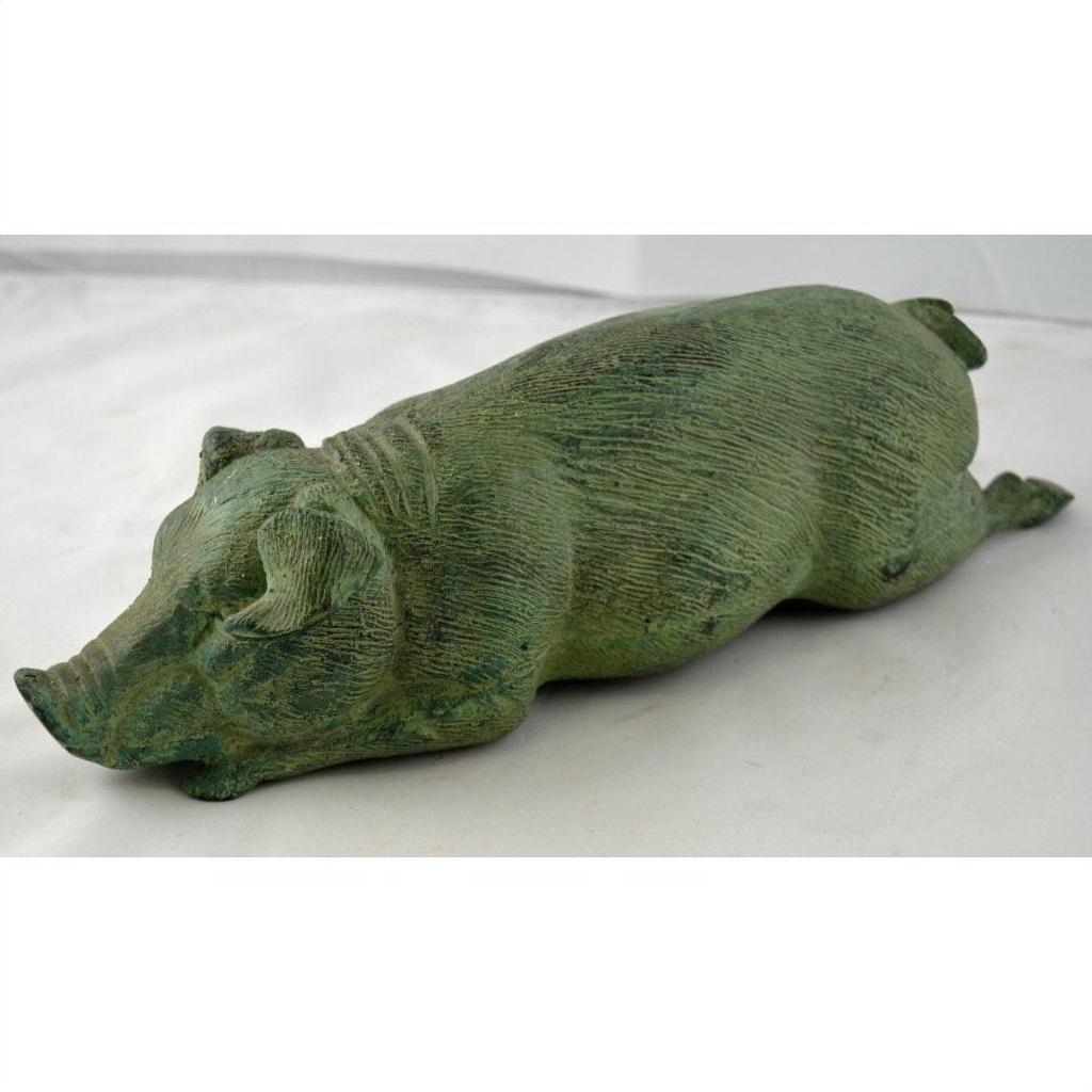 Green bronze pig sculpture with textured surface, reclining with outstretched legs, tabletop decor close-up.