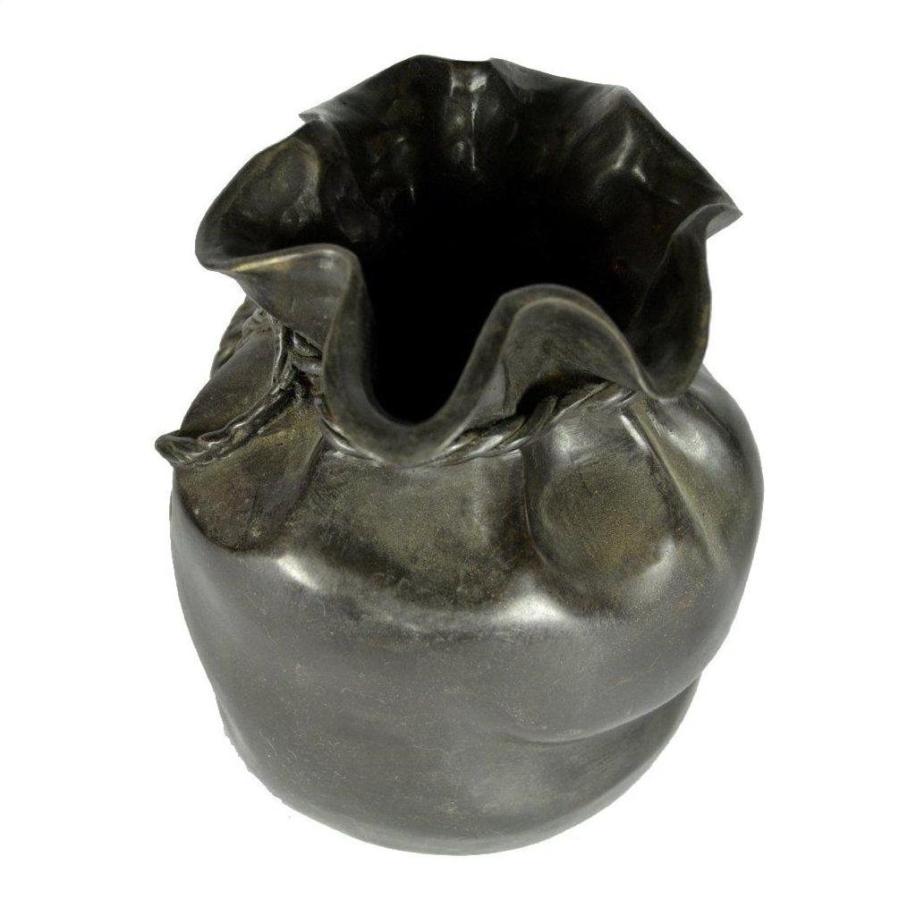 Black ceramic vase with ruffled rim and textured, rounded body, shown on tabletop for display.