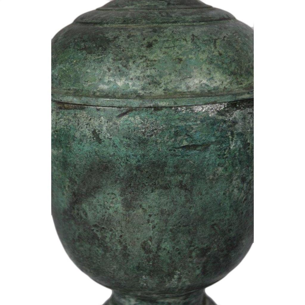 Close-up of a green patina bronze urn with textured surface and rounded lid, lost wax cast.