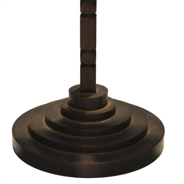 Close-up of a bronze-colored metal candle holder with tiered, geometric ridged design and modern vertical stem.