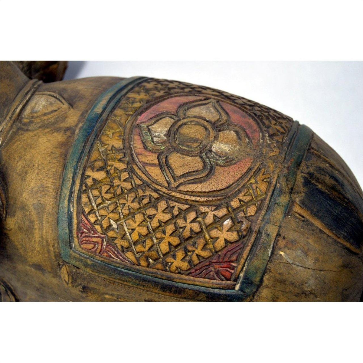 Close-up of a hand-carved Chiang Mai wooden elephant with detailed floral and geometric patterns, in very good condition.