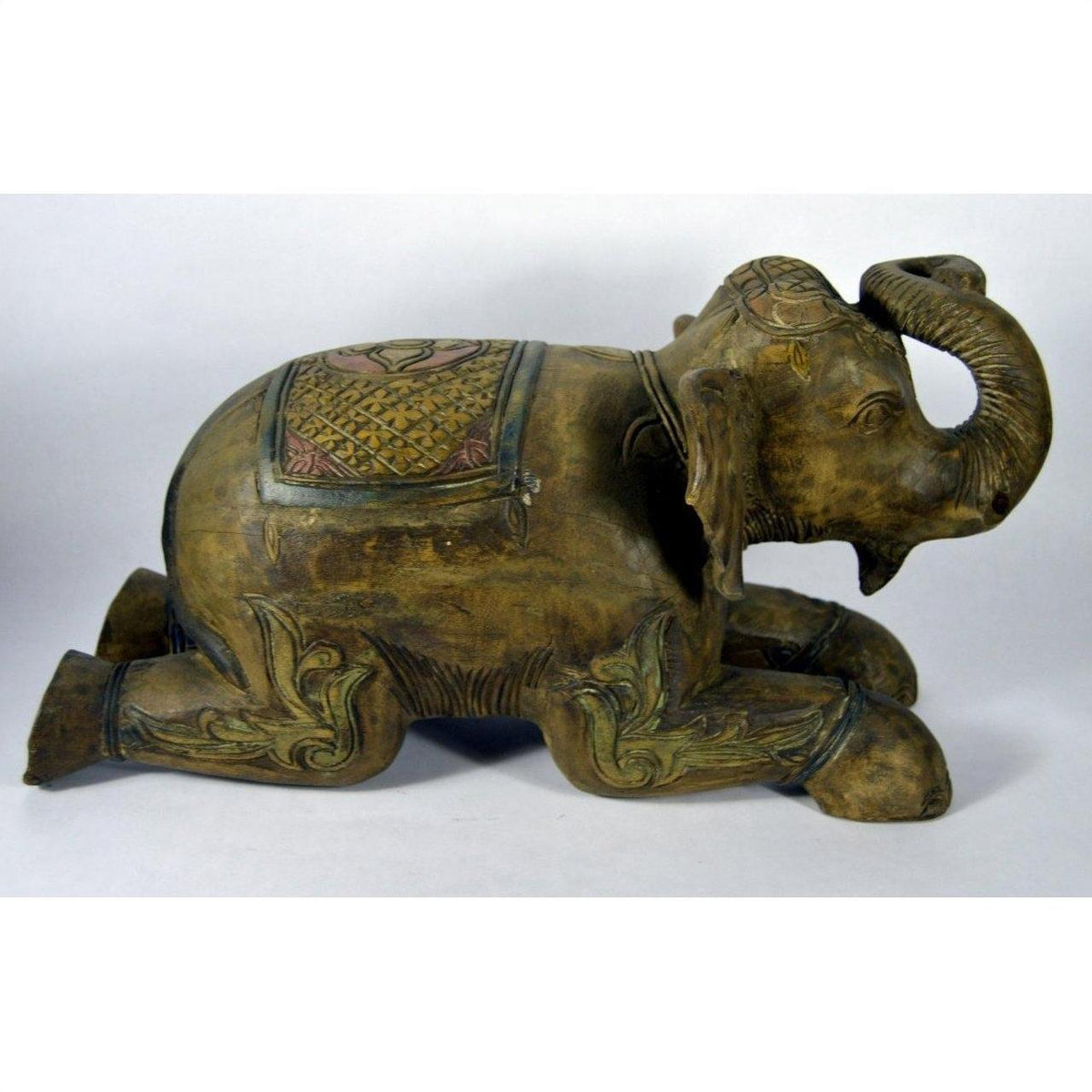 Bronze elephant statue with ornate carvings and blanket, kneeling, in good condition.