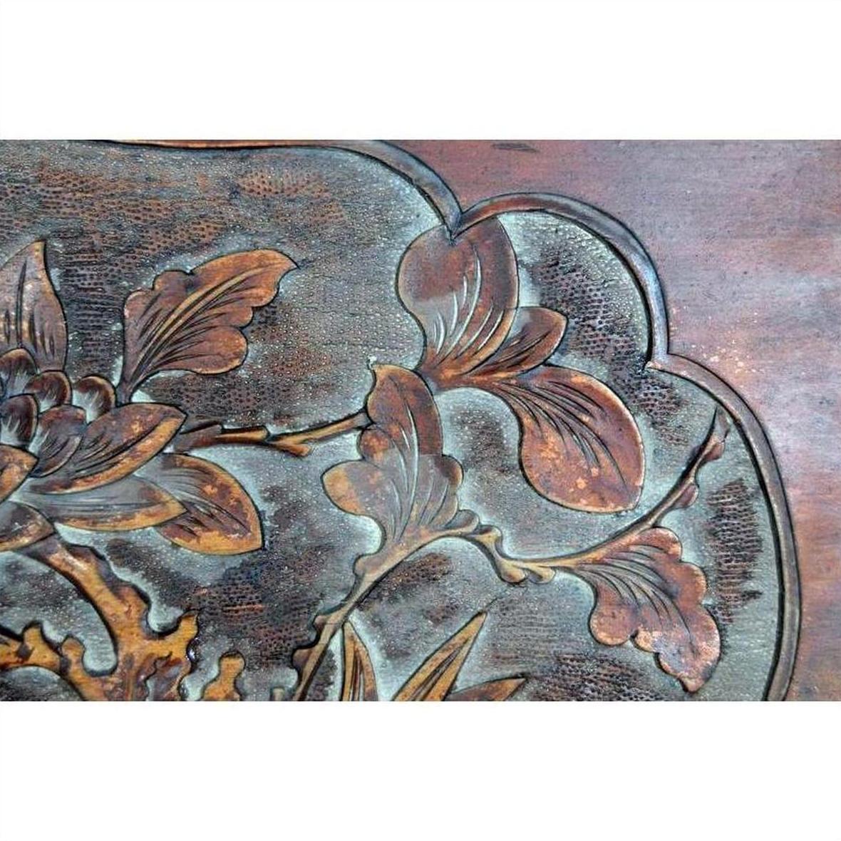 Close-up of 19th-century rosewood wall plaque, hand-carved with lacquered bird and foliage detailing.