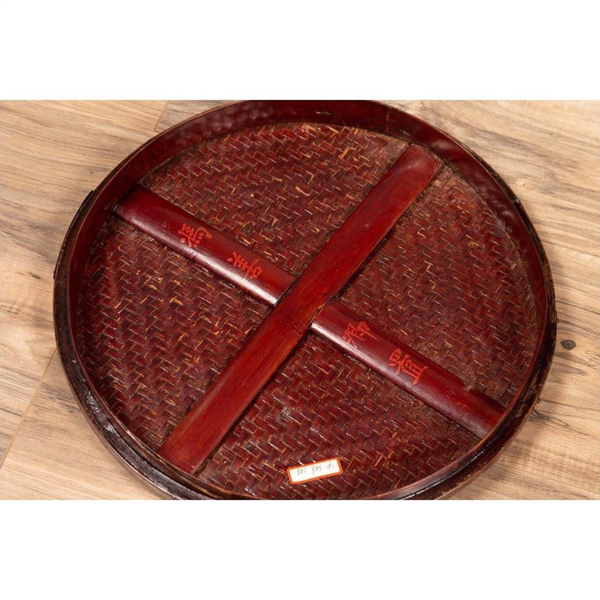 Brown wooden tiered Chinese food basket with red characters, stacked parts on a wooden surface.