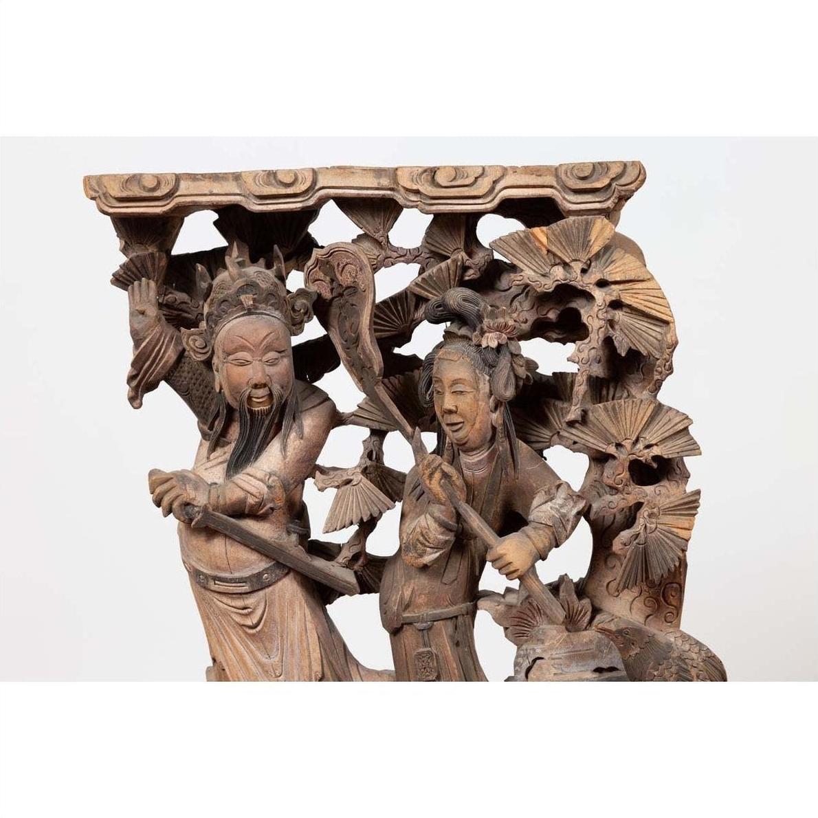 Brown wood hand carved Chinese corbel with deities in traditional attire, 1900s, on decorative base.
