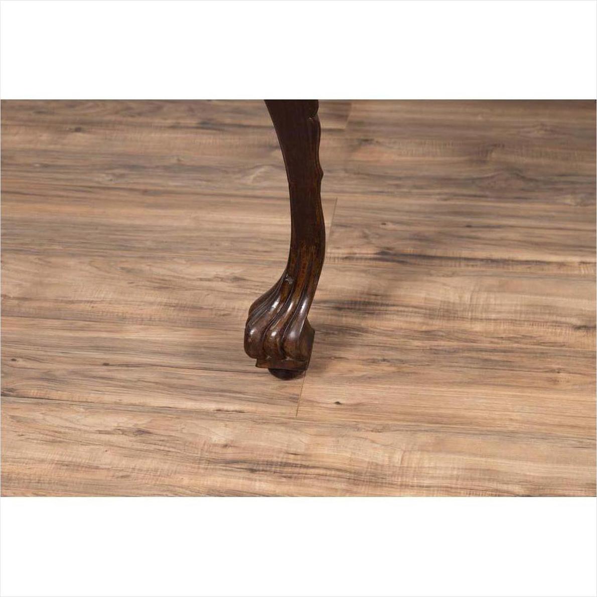 Close-up of dark wood cabriole leg table with black lacquered top on light wood floor indoors.