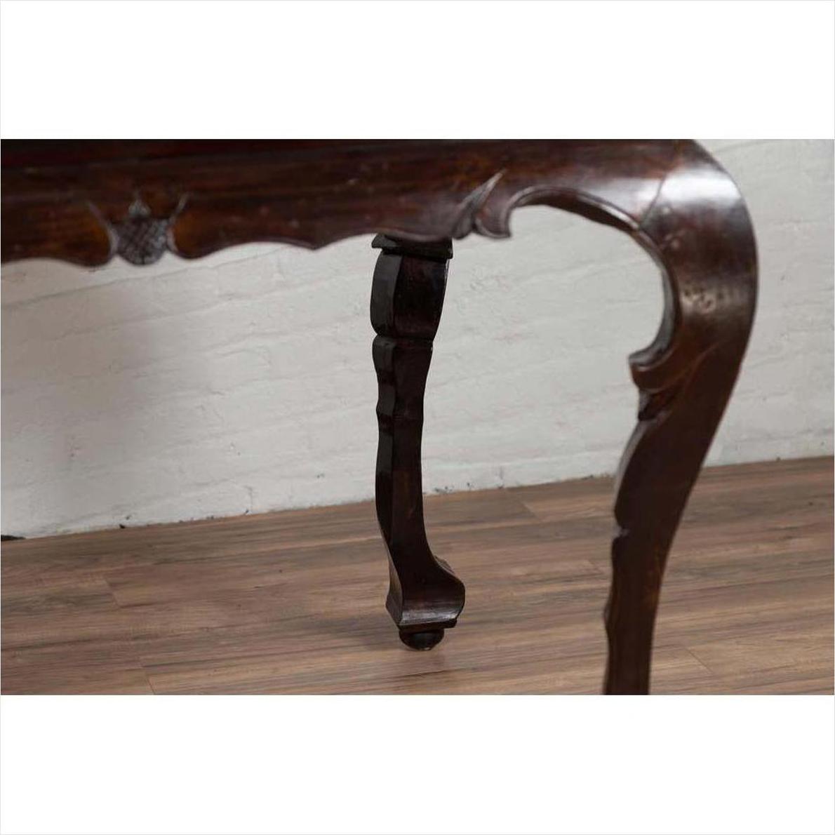 Close-up of black lacquered wood Chinese antique center hall table with cabriole legs on wooden floor indoors.