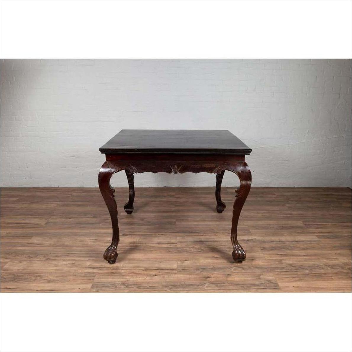 Black lacquered wood hall table with cabriole legs and claw feet, positioned on a wooden floor indoors.