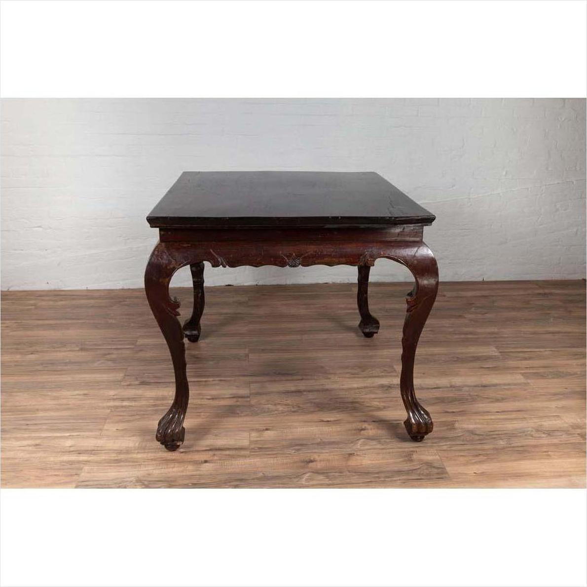 Black lacquered wood hall table with cabriole legs, positioned indoors against a white wall.