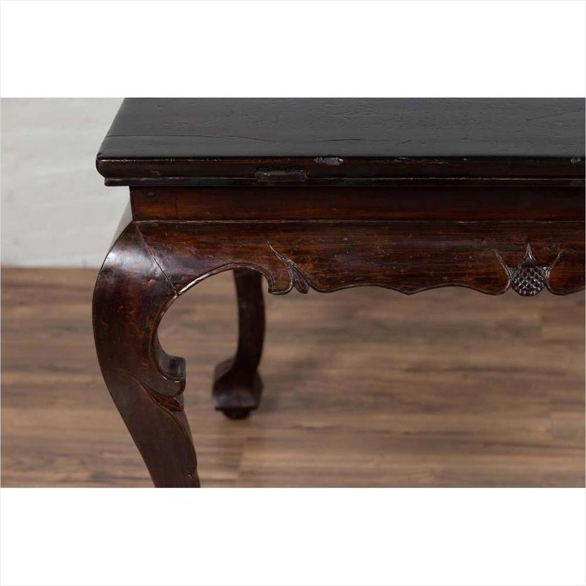 Black lacquered wood hall table with cabriole legs, displayed indoors on a wooden floor by a light wall.