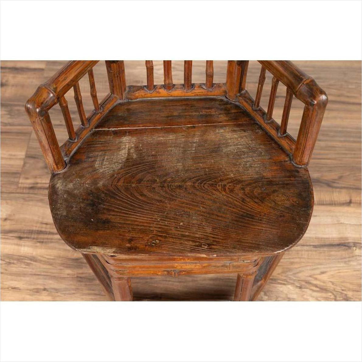 Brown bamboo Chinese antique child's corner chair with hexagonal base on wood floor.