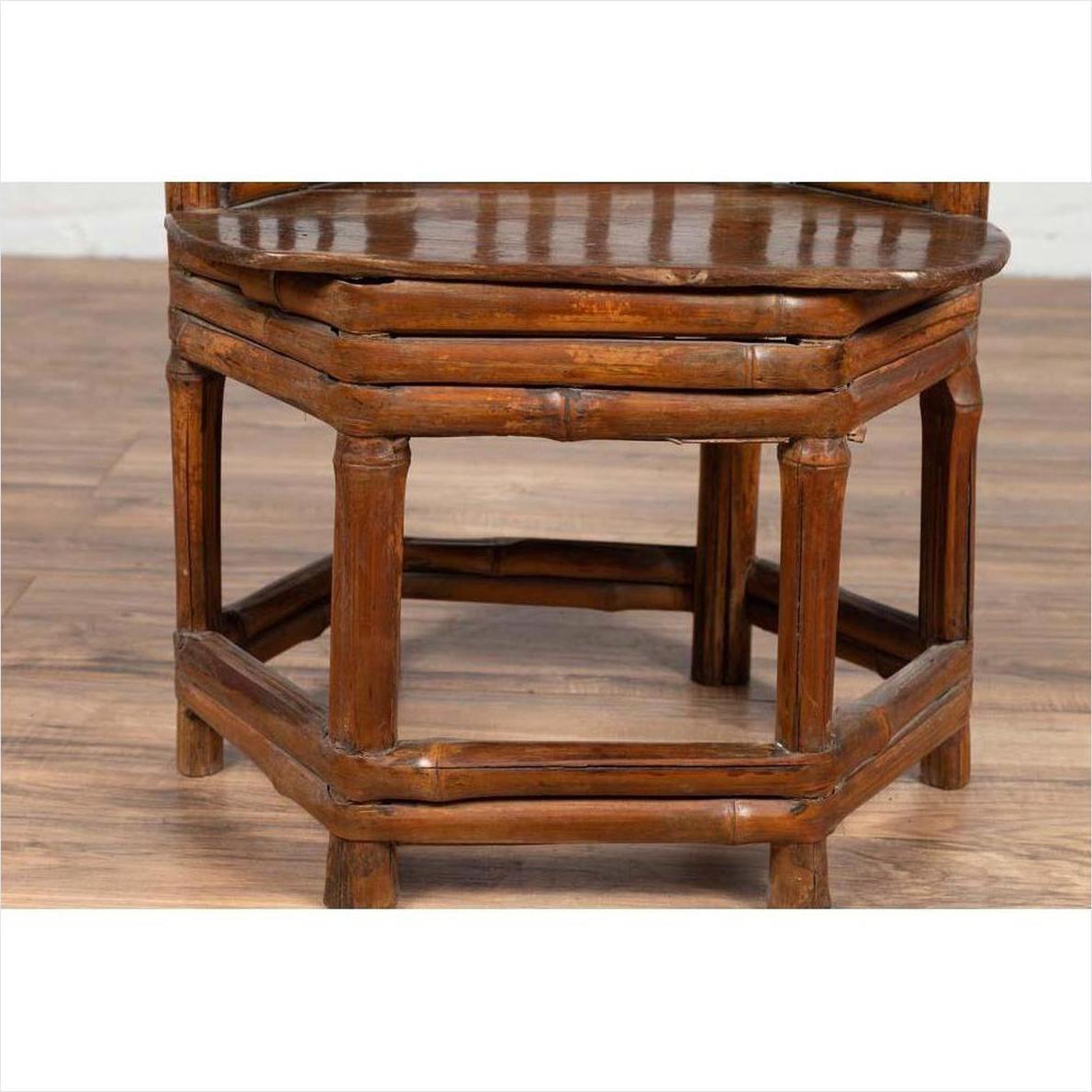 Close-up of a brown bamboo Chinese antique child's corner chair with hexagonal base.