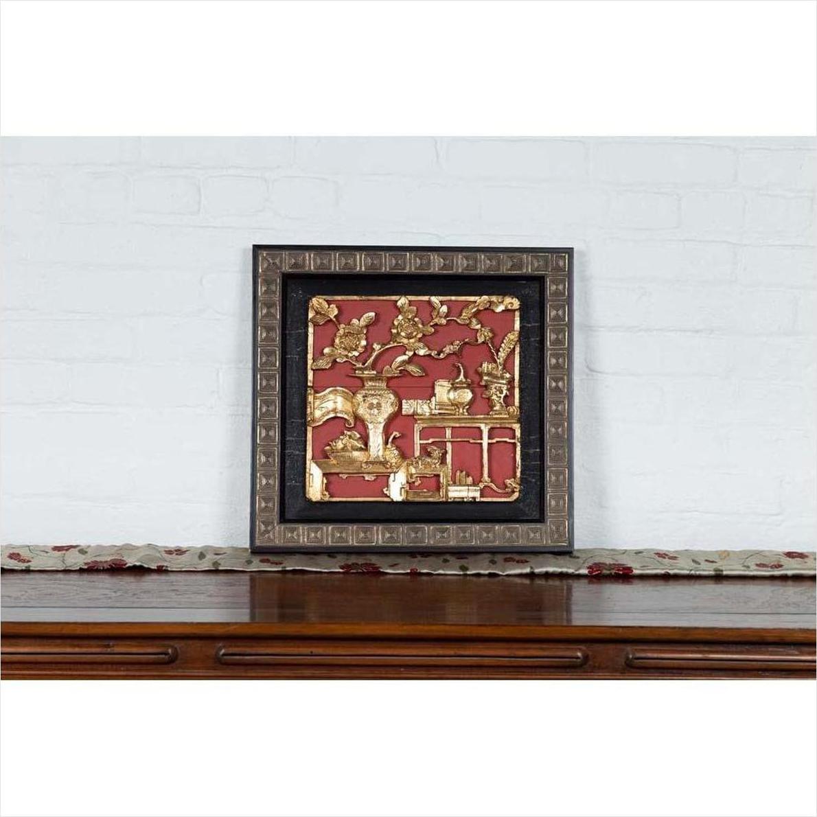 Red and gold giltwood Chinese antique floral architectural panel on wooden table.