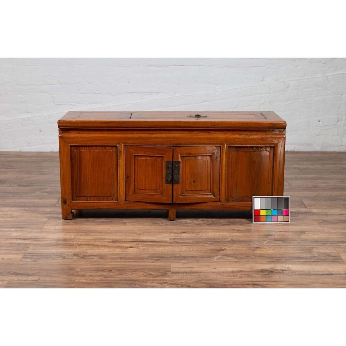 Brown wood two-door buffet with faux doors and upper removable panel on wooden floor, color card in front.