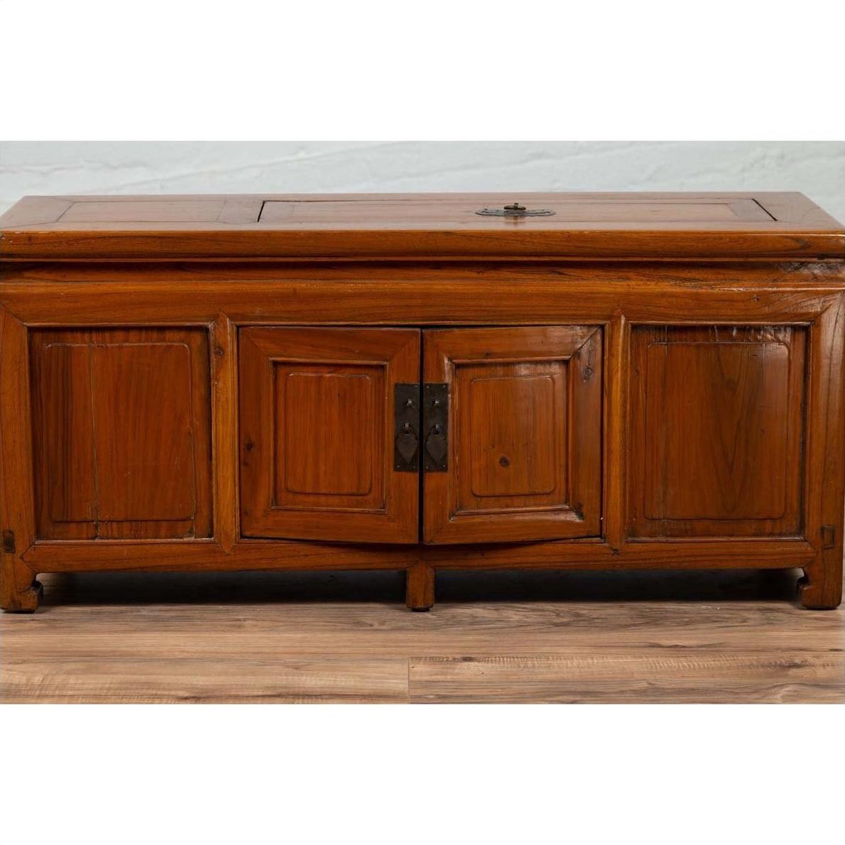 Brown wood two-door buffet with faux doors and removable upper panel on wood floor against a light wall indoors.